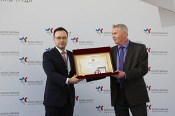 Инженер по охране труда и промышленной безопасности Приморского ЛПУМГ Владимир Морозов (справа) получает всероссийскую награду